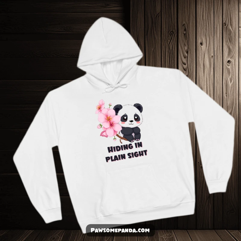 Funny hoodie with a panda gently peeking from behind a lush, blooming cherry blossom tree, creating a sense of wonder.